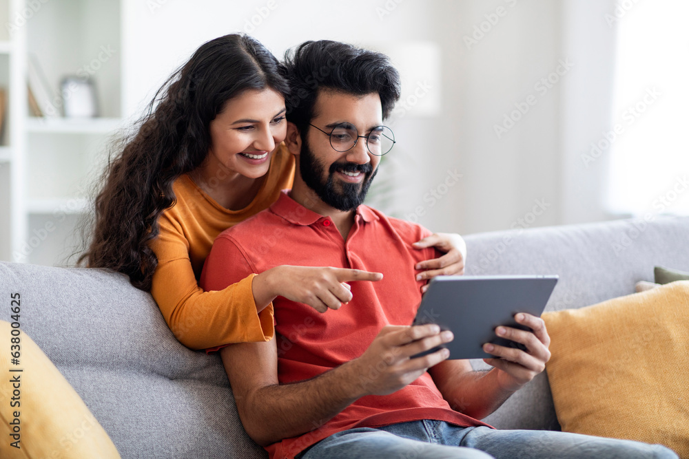 Great App. Indian Couple Using Digital Tablet In Living Room At Home