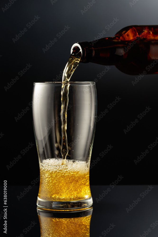 Pouring beer from a bottle into a glass.