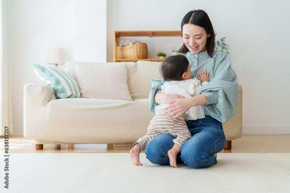 よちよち歩きする赤ちゃんを支えるお母さん