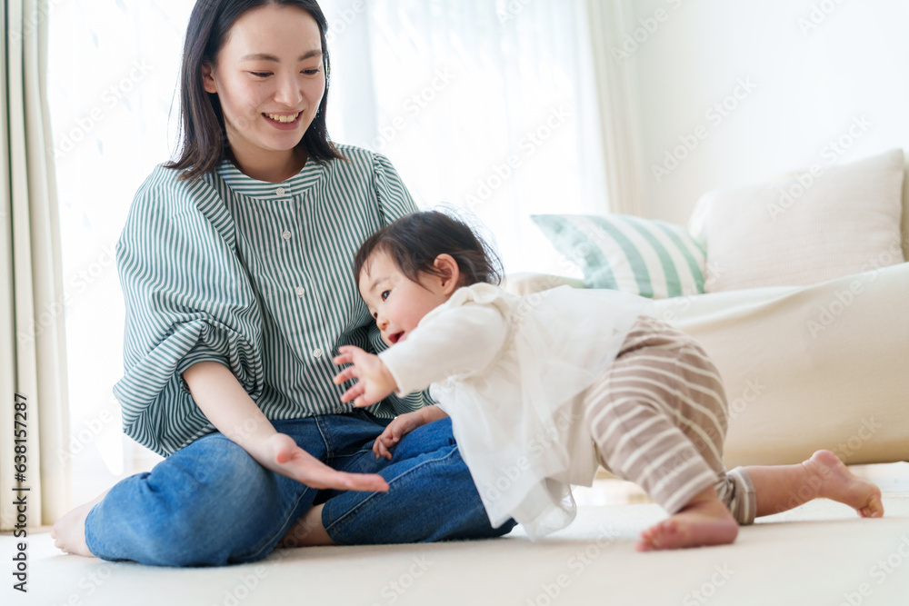 リビングで赤ちゃんと遊ぶお母さん