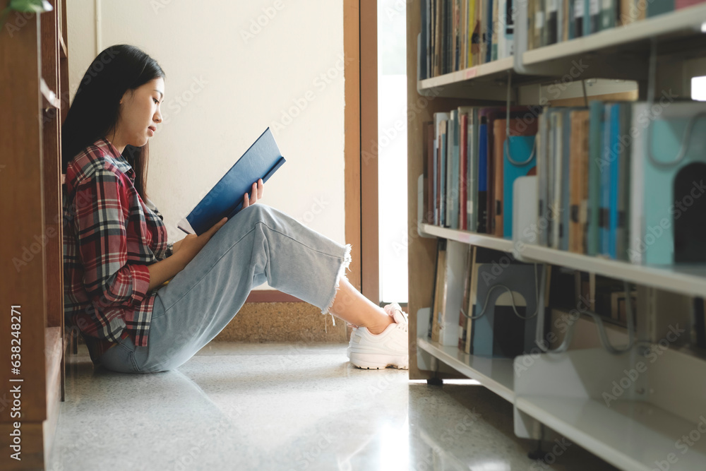 University students reading books in library for research.