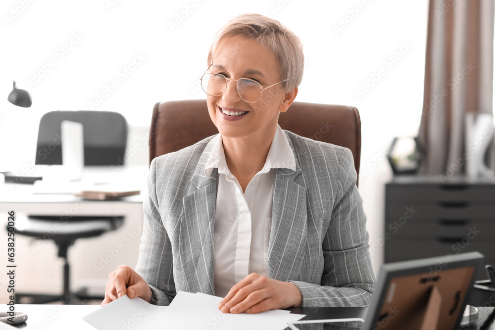 Mature businesswoman working with papers in office