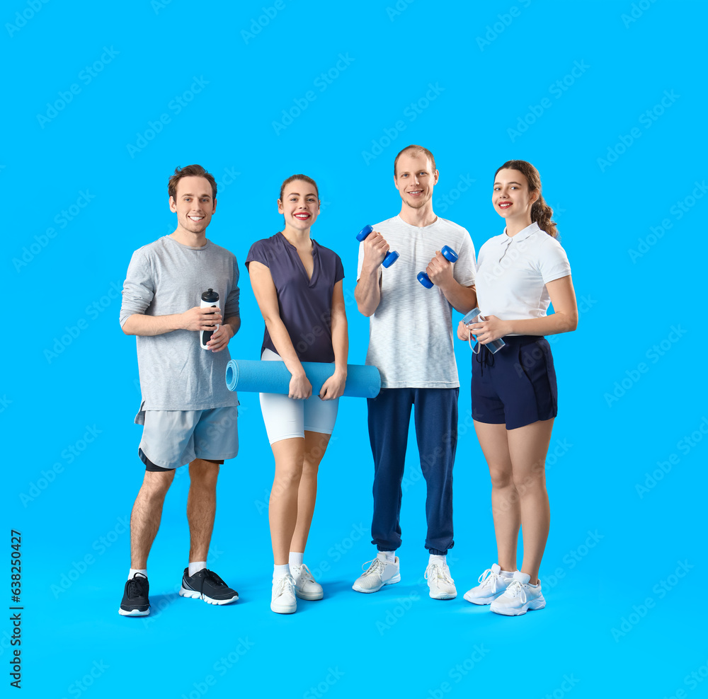 Group of sporty young people with equipment on blue background