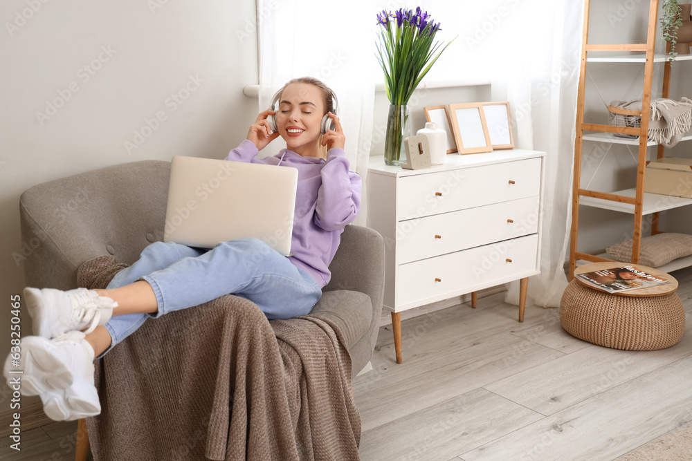 Female student with headphones and laptop at home