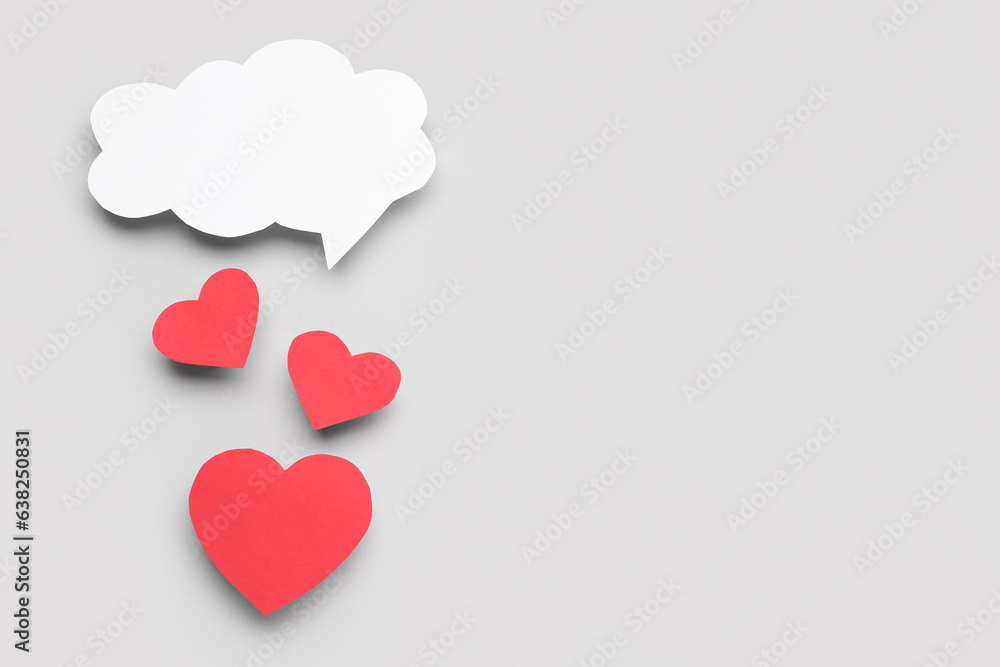 Paper hearts with blank speech bubble on grey background