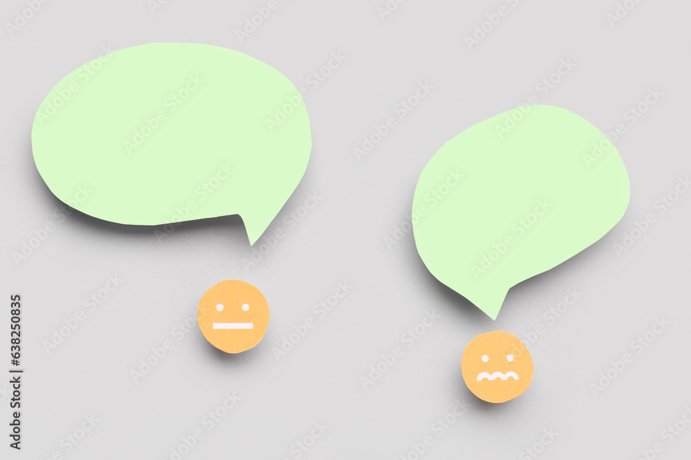 Arguing paper faces with blank speech bubbles on grey background