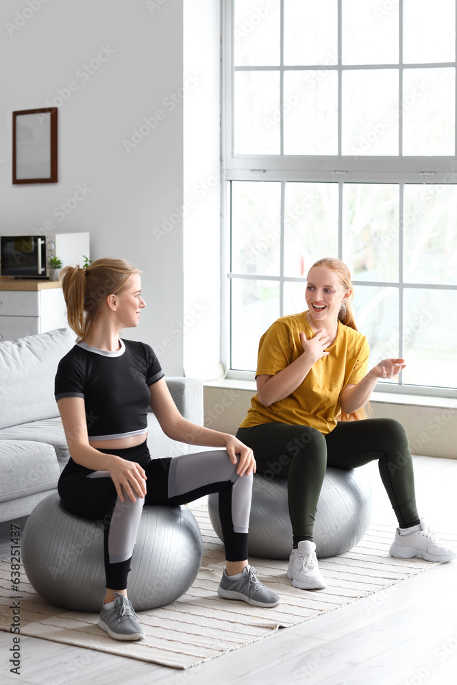 Sporty young women training with fitballs at home