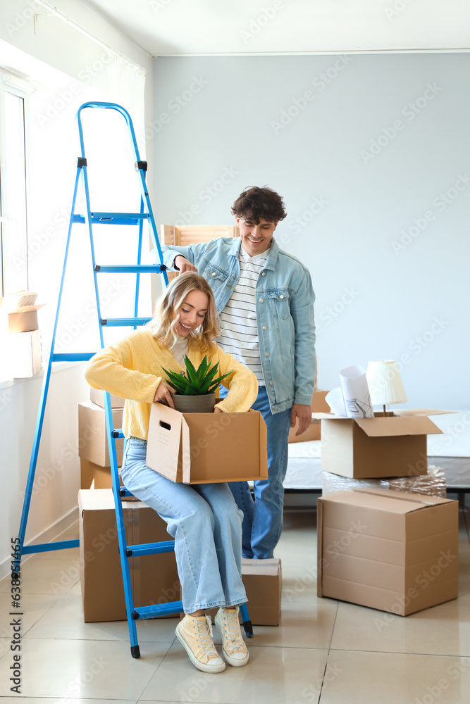 Young couple packing things in bedroom on moving day