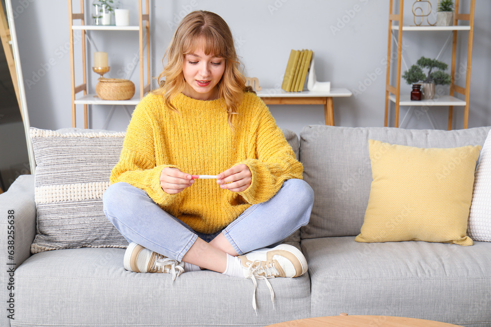 Young woman with pregnancy test at home