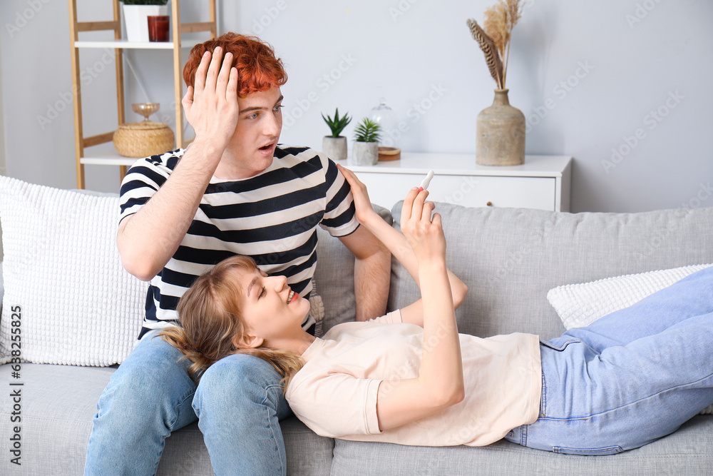 Happy young couple with pregnancy test at home