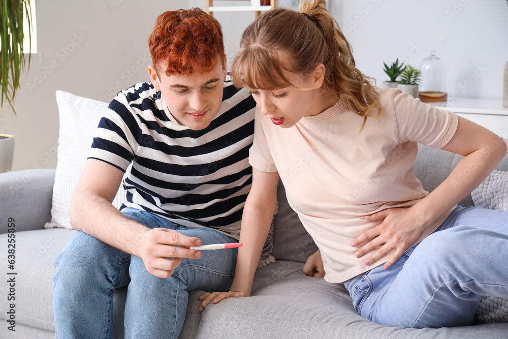 Happy young couple with pregnancy test at home