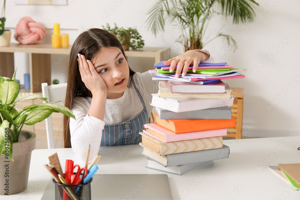 Shocked little girl with stack of schoolbooks at home