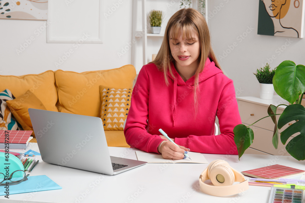 Female student with laptop doing lessons at home