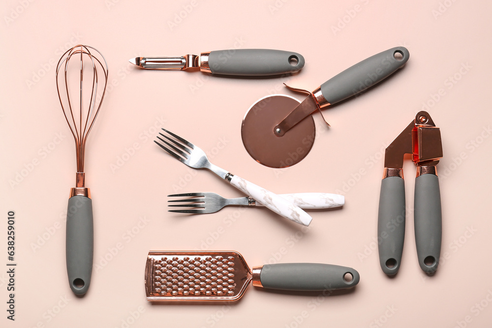 Set of different kitchen utensils on beige background