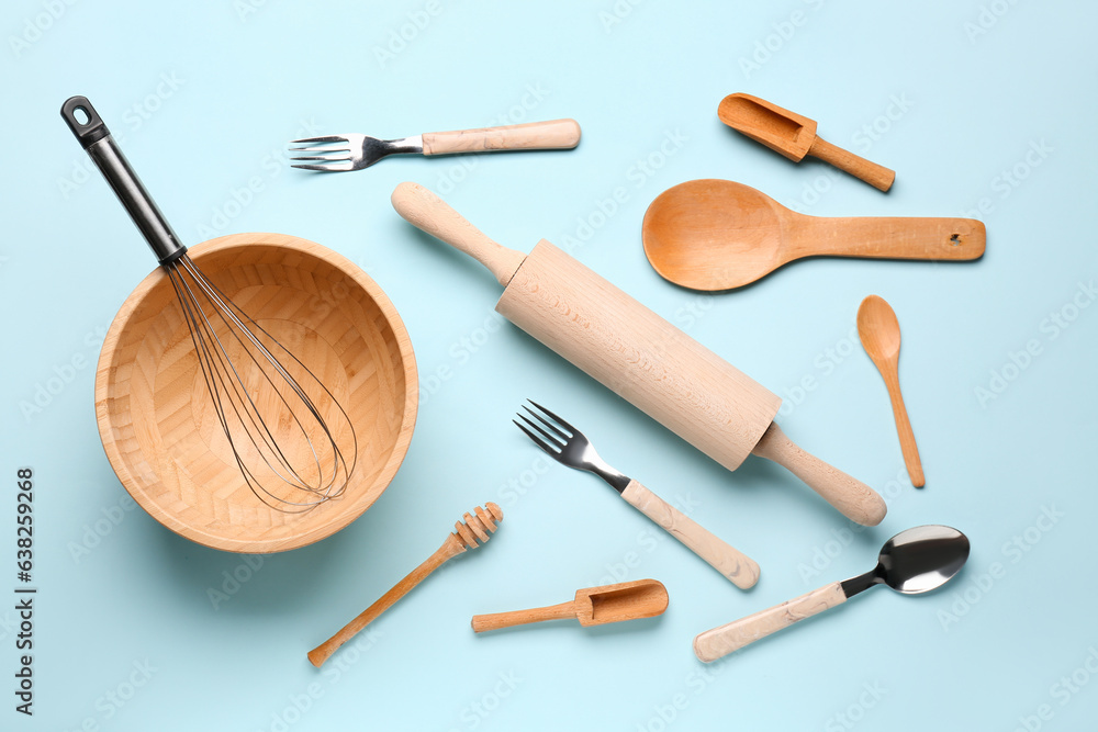 Set of wooden kitchen utensils on blue background