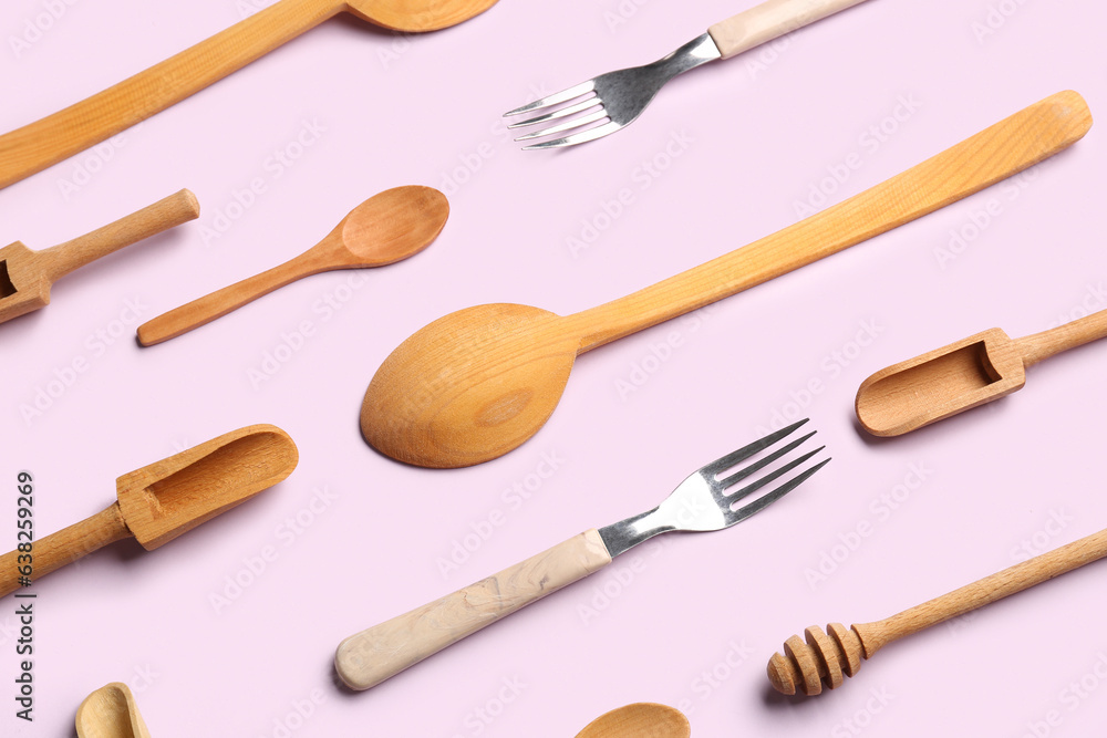 Wooden kitchen utensils on lilac background