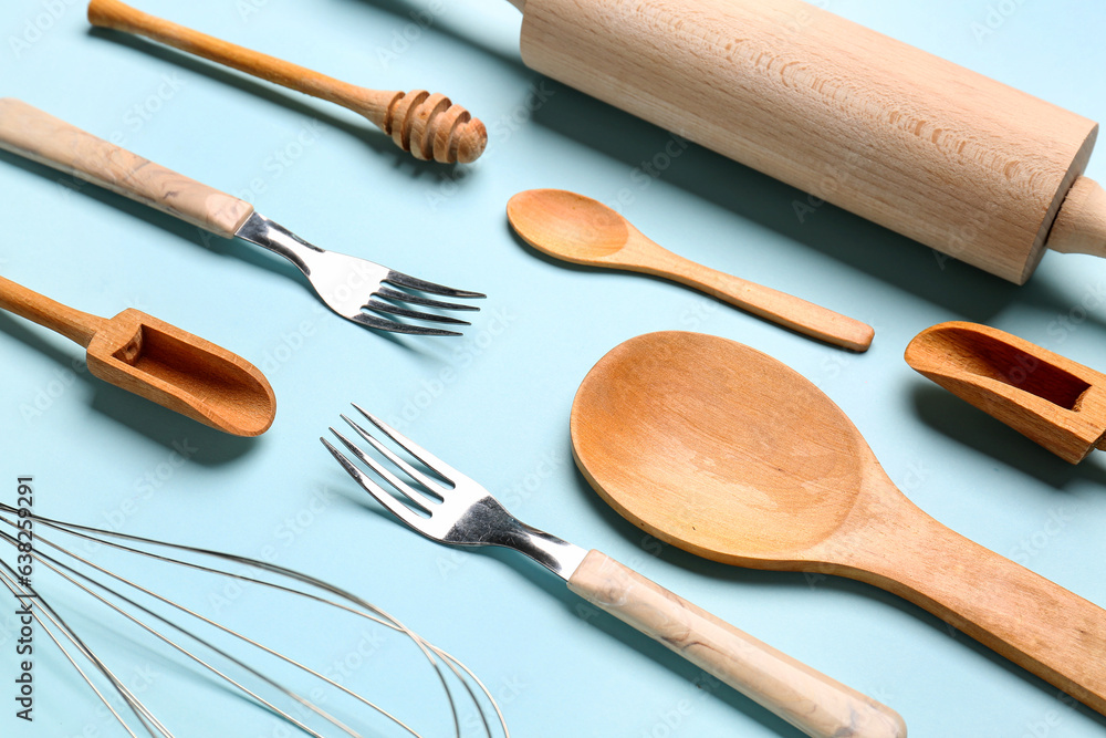 Set of wooden kitchen utensils on blue background