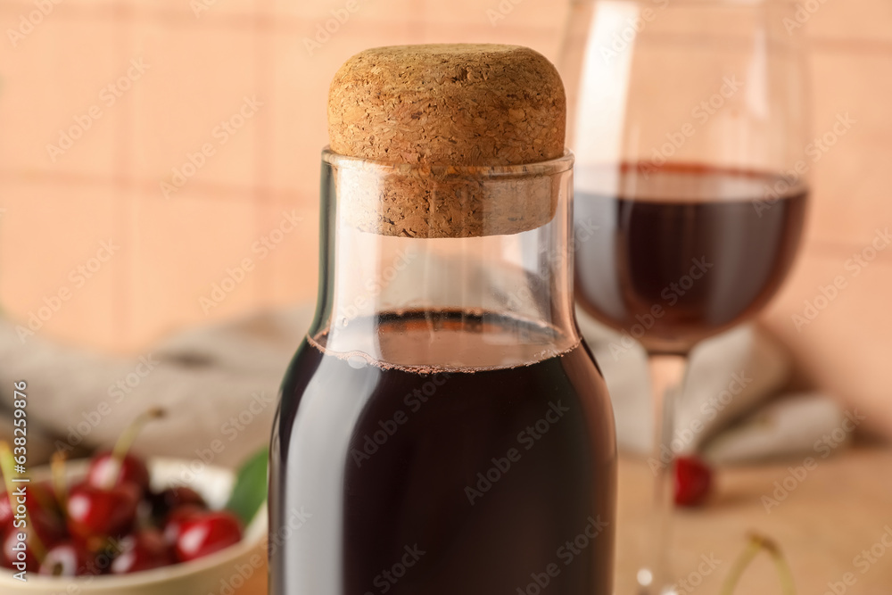 Bottle of sweet cherry liqueur on beige tile background