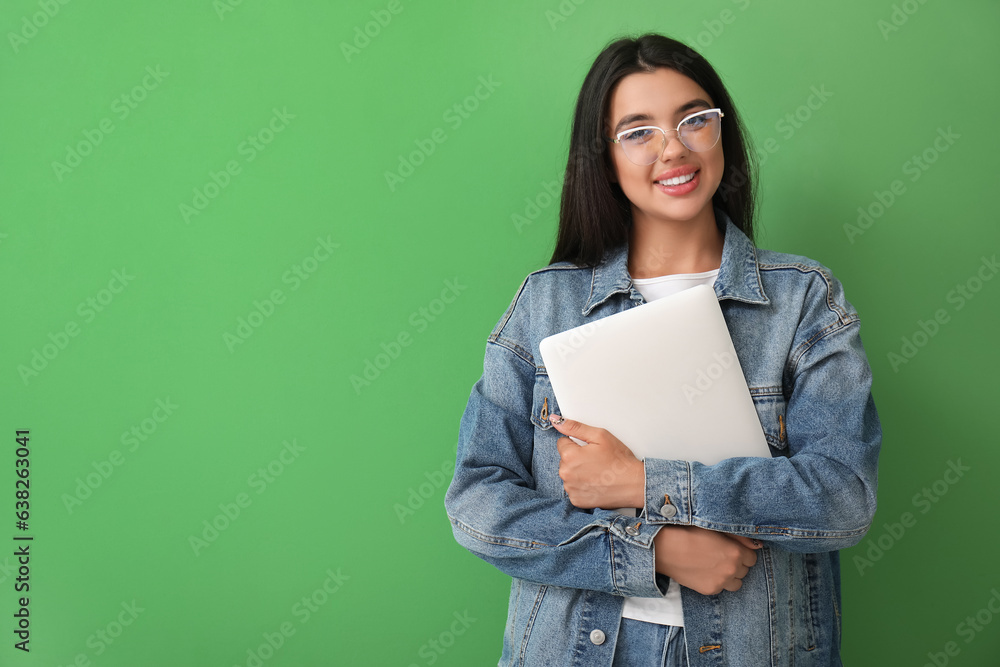 Happy female programmer with laptop on green background