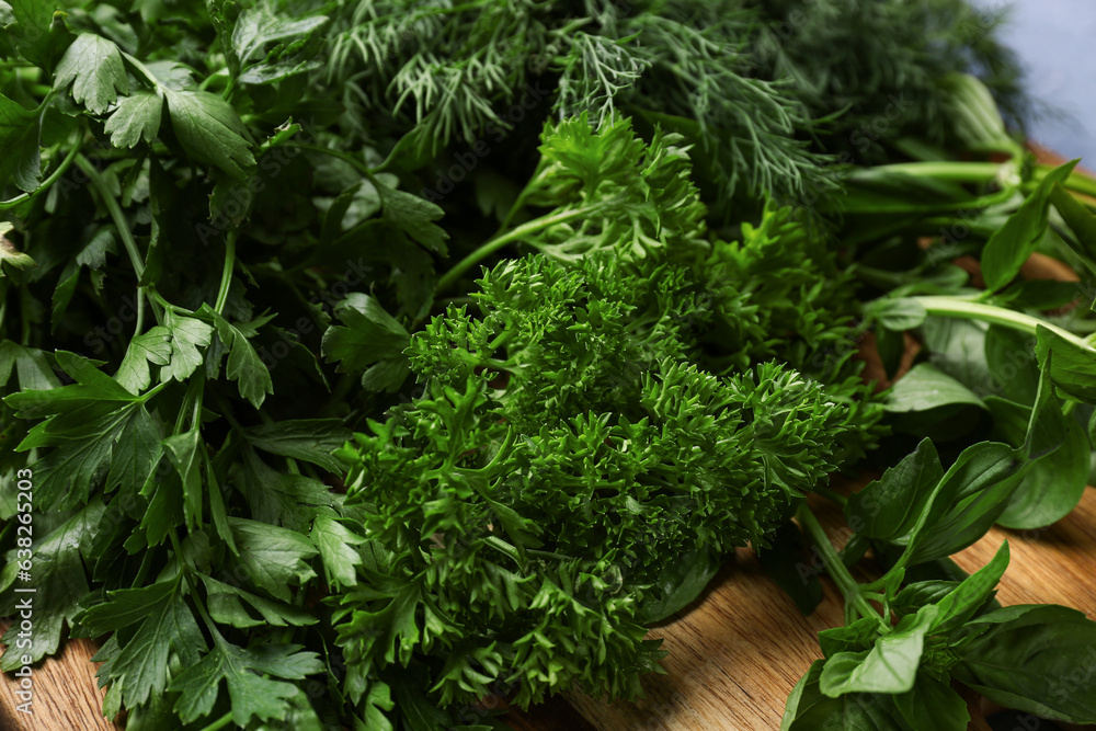 Wooden board with fresh herbs, closeup