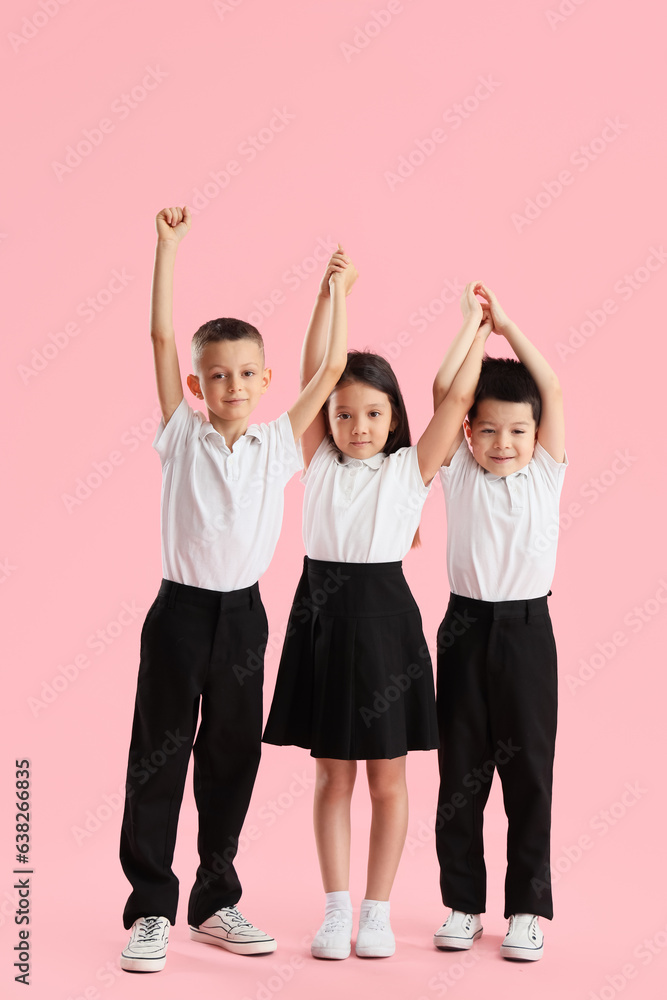 Happy little school children on pink background