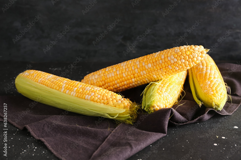 Fresh corn cobs on black background