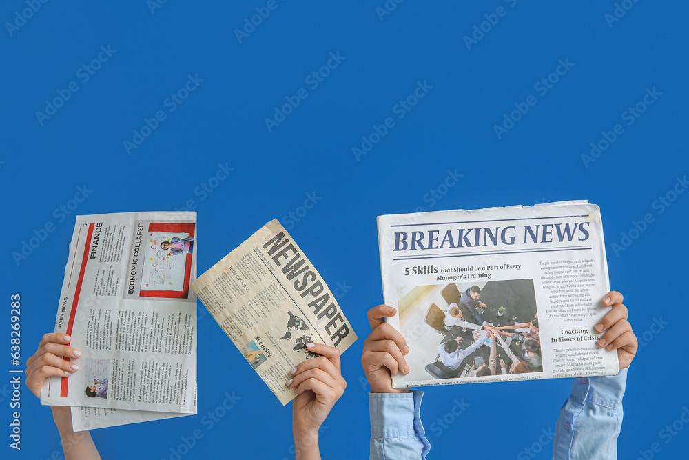 Female hands with newspapers on blue background