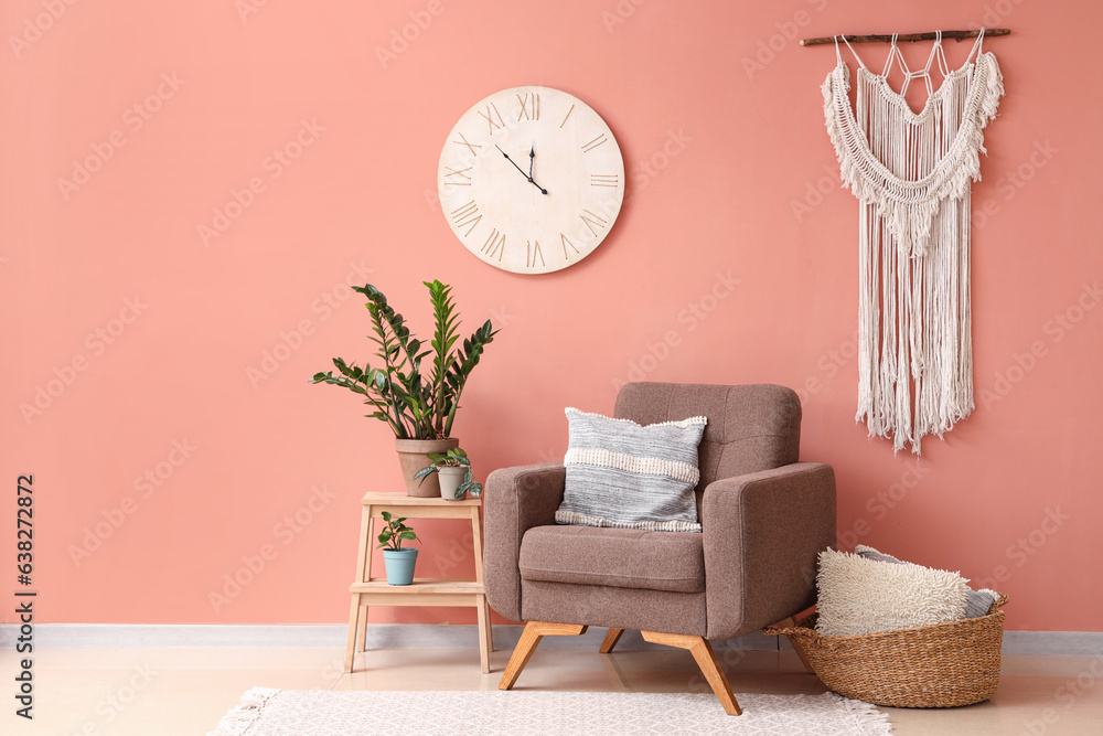 Stylish brown armchair and houseplant on stepladder near color wall