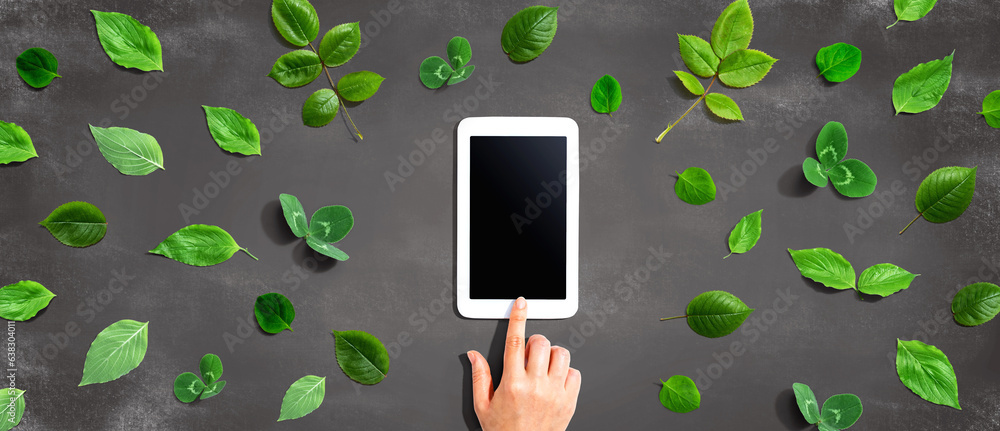 Green leaves with a tablet computer - flat lay