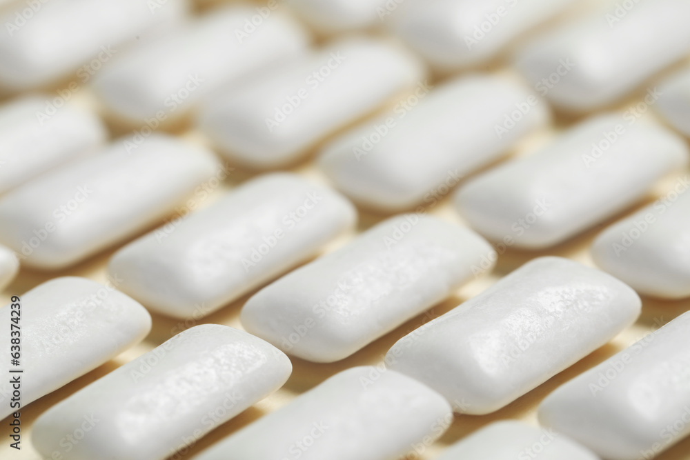 Tasty white chewing gums on beige background, closeup