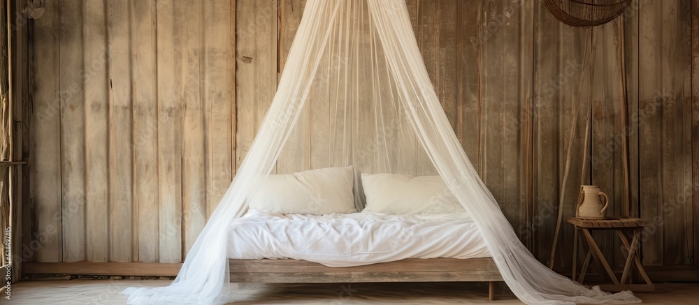 Old style mosquito curtain in a house or hut with a bed adorned with white linen pillows and a mosqu