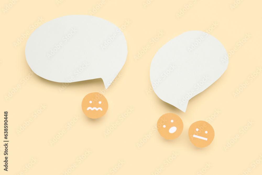 Paper faces with blank speech bubbles on yellow background