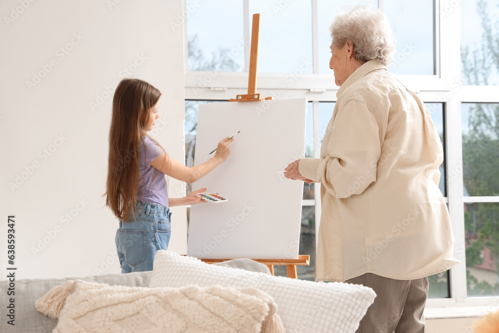 Little girl with her grandmother drawing at home