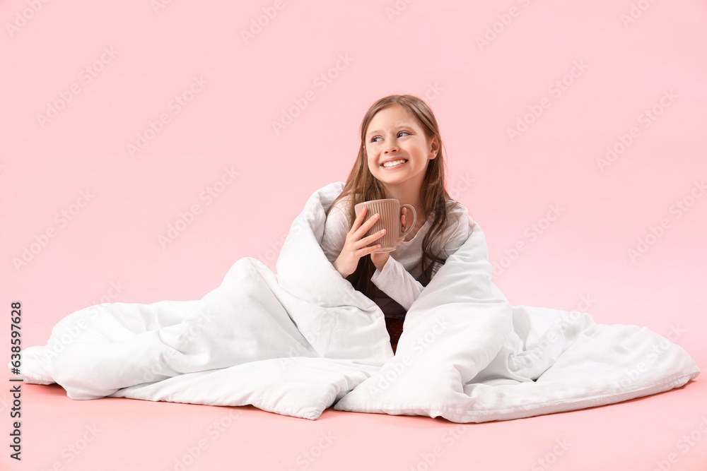 Little girl with blanket and cup of milk on pink background