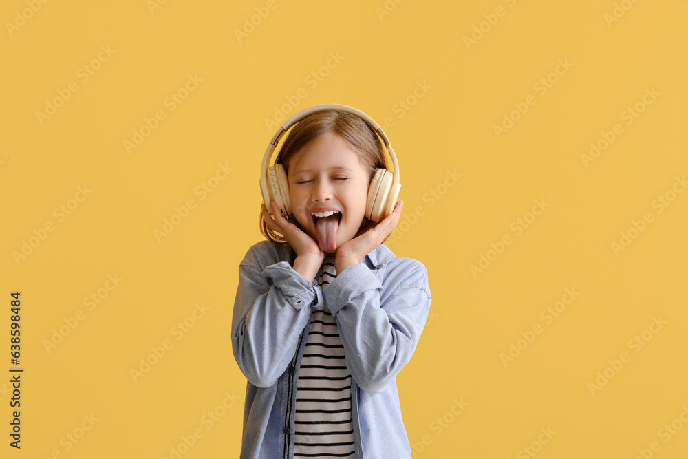 Little girl in headphones on yellow background