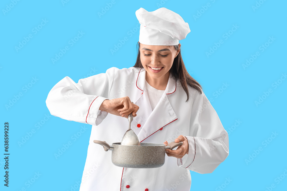 Female chef with cooking pot on blue background