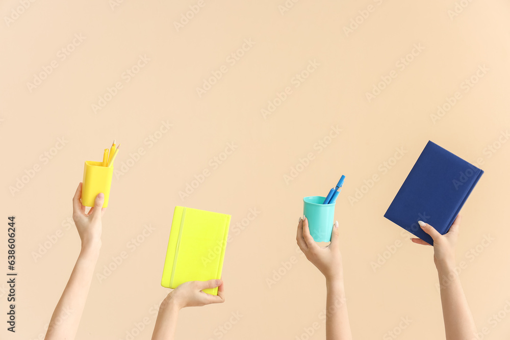 Hands holding school supplies on beige background