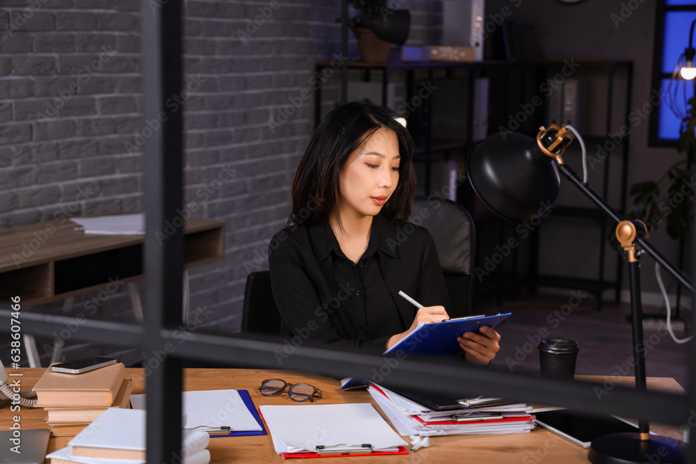 Young Asian businesswoman working in office at late evening