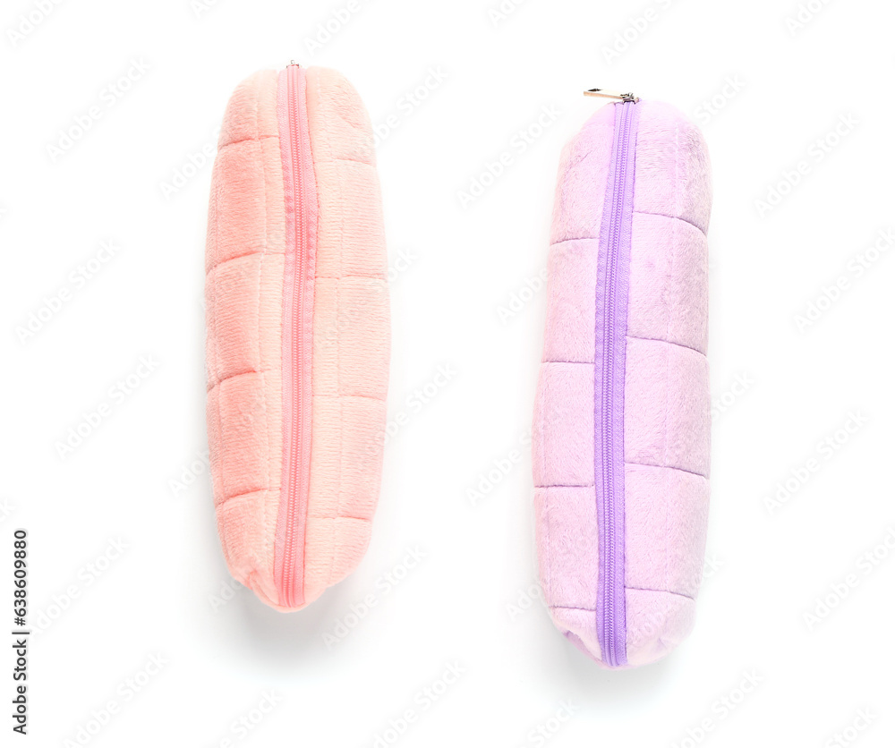 Pink and purple pencil cases on white background