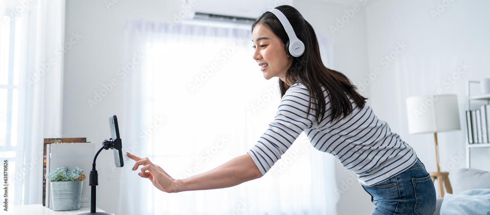 Asian attractive woman enjoy dance with music in living room at home. 