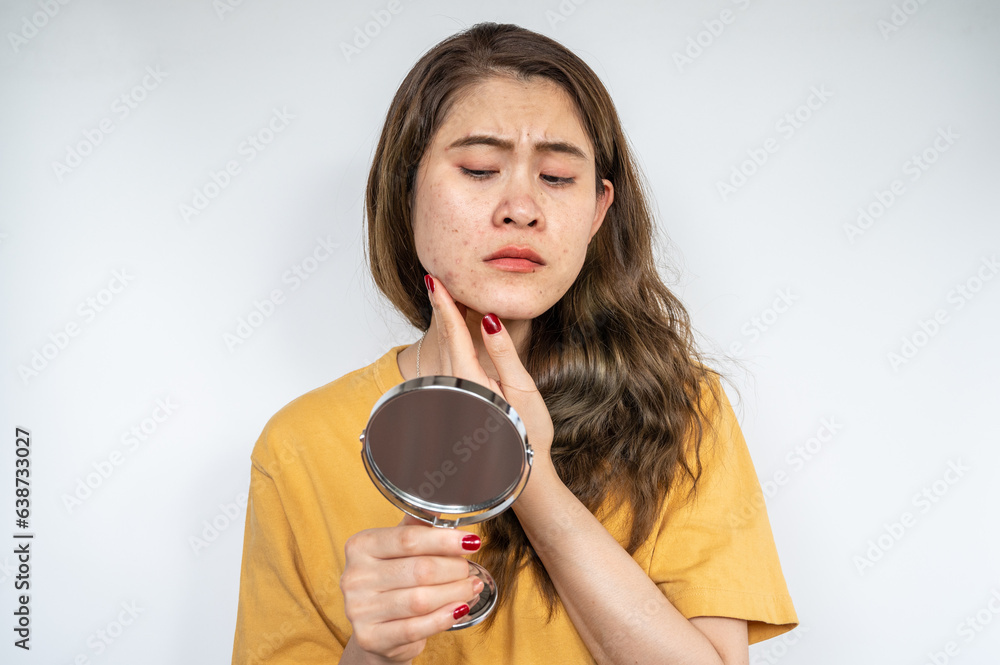 Portrait of Asian woman worry about her face when she saw the problem of acne inflammation occur on 