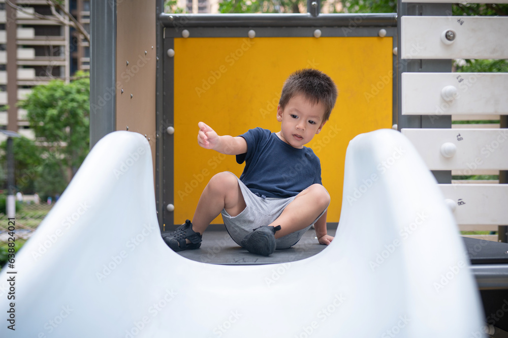 A boy is playing on a slide.