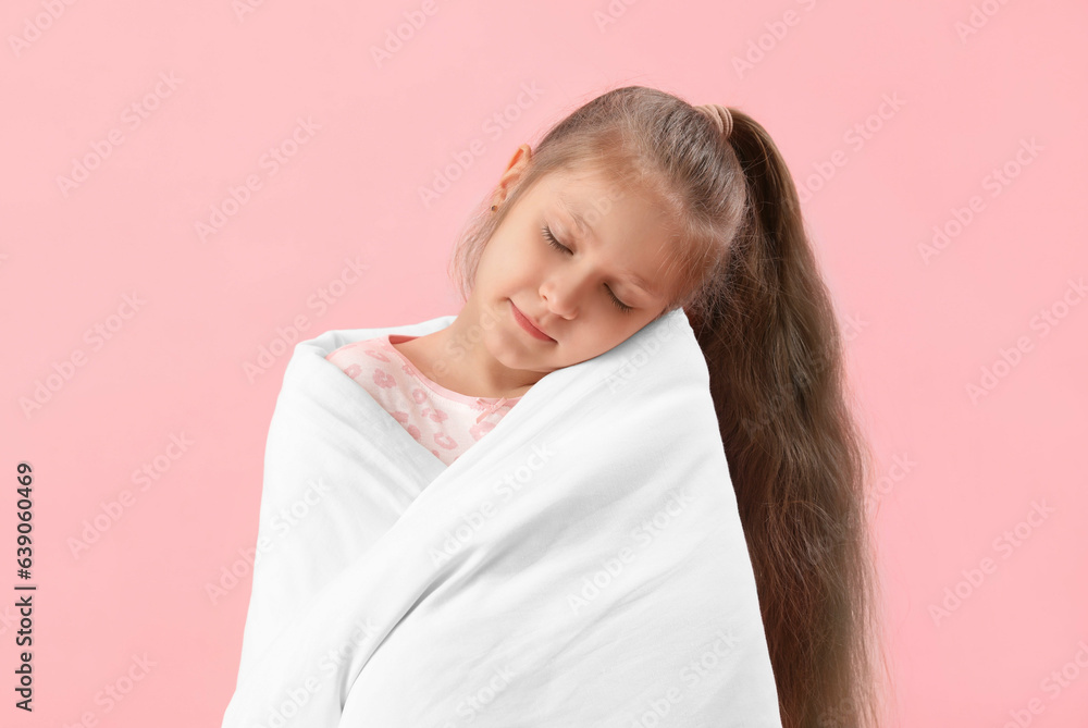 Little girl with soft blanket on pink background