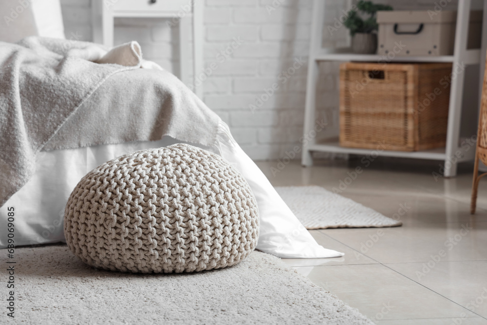 Knitted pouf on floor in bedroom room, closeup