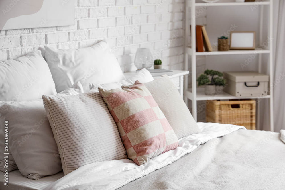 Big bed with pillows in light bedroom