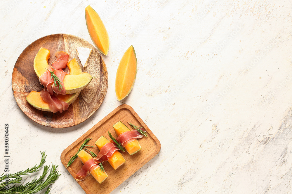 Composition with tasty melon, prosciutto and rosemary on light background