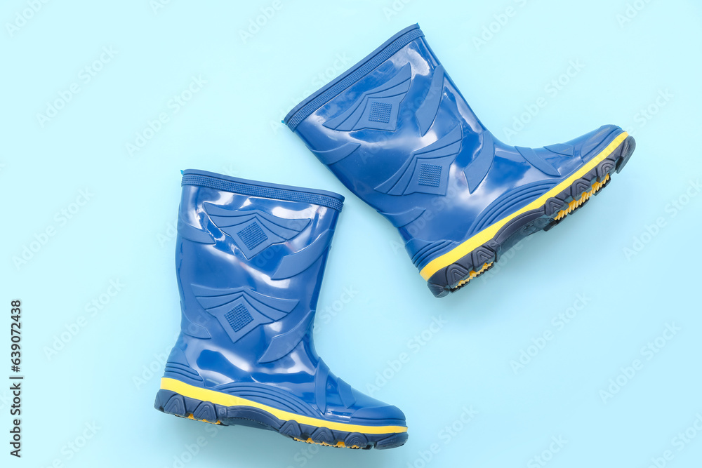 Blue gumboots on color background