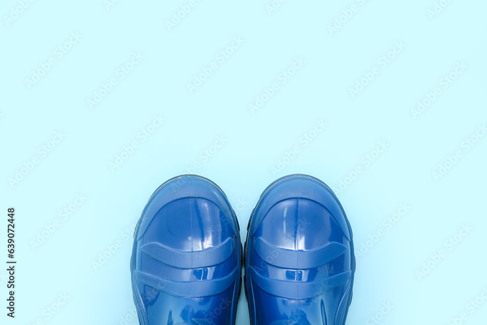 Blue gumboots on color background