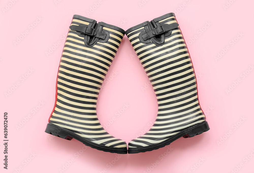 Stylish gumboots on pink background