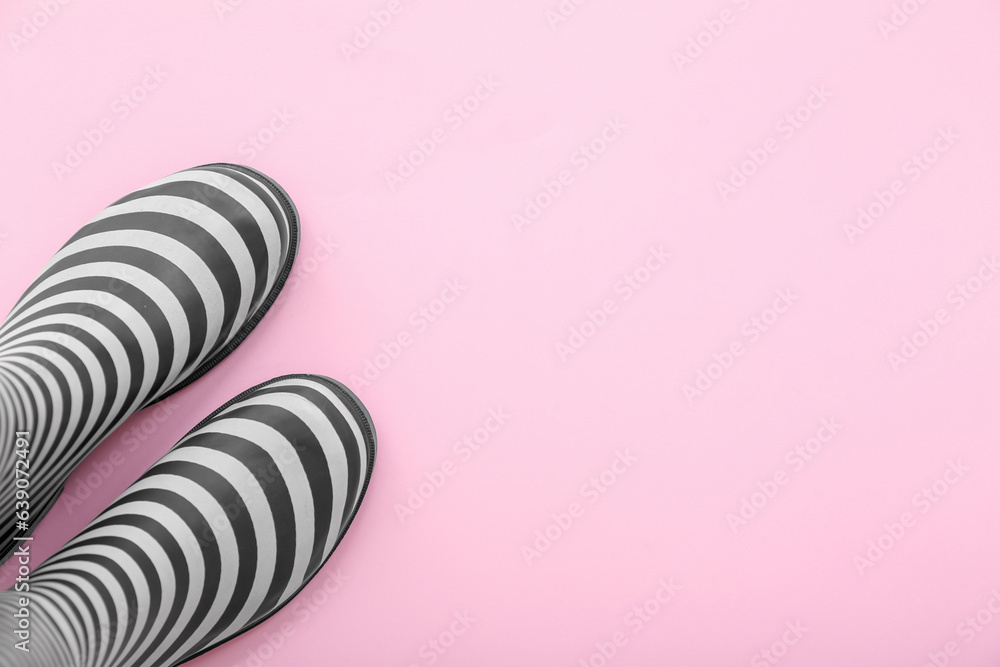 Stylish gumboots on pink background